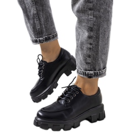 Scarpe nere su suola di un trattore Feline nero