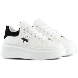 Scarpe sportive bianche con suola spessa e un orsacchiotto nero bianco