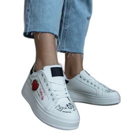 Sneaker bianche decorate con patch e scritte sulla piattaforma bianca