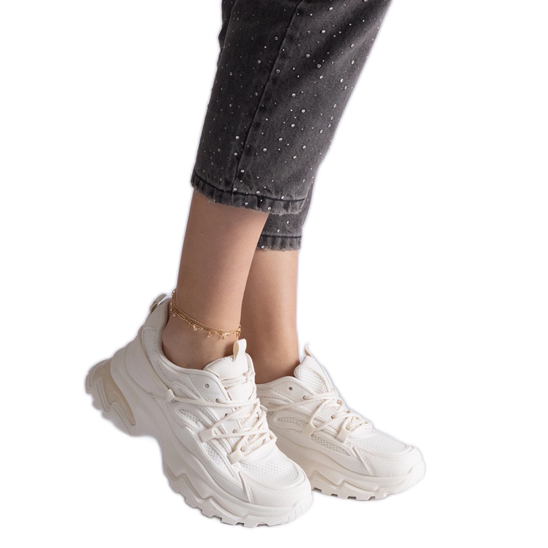 Sneaker sportive beige su una suola enorme