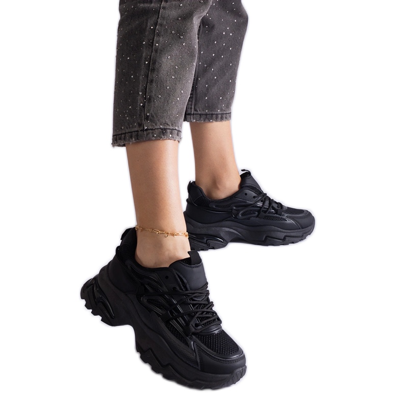 Sneaker sportive nere su una suola enorme nero
