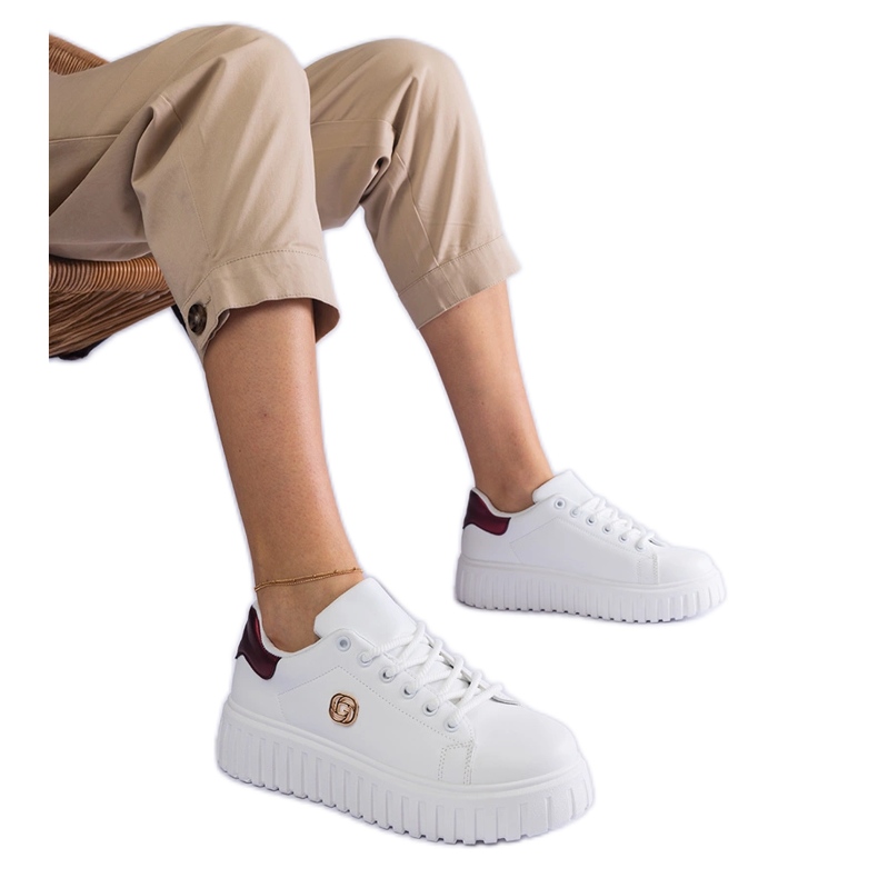 Sneaker bianche e bianche su una suola spessa bianca