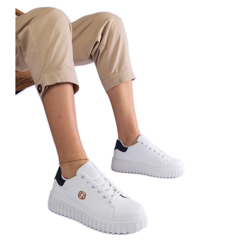 Sneaker bianche e bianche su una suola spessa bianca