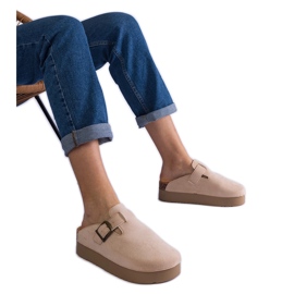 Le infradito da donna beige sulle donne sulla piattaforma con una fibbia