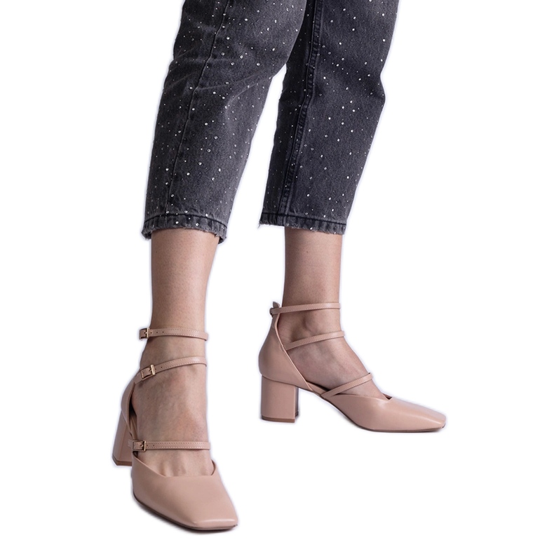 Pompe beige sul pilastro con fibbie