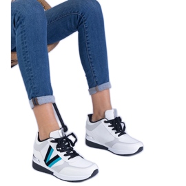 Sneaker da donna bianca su un cuneo nascosto bianco