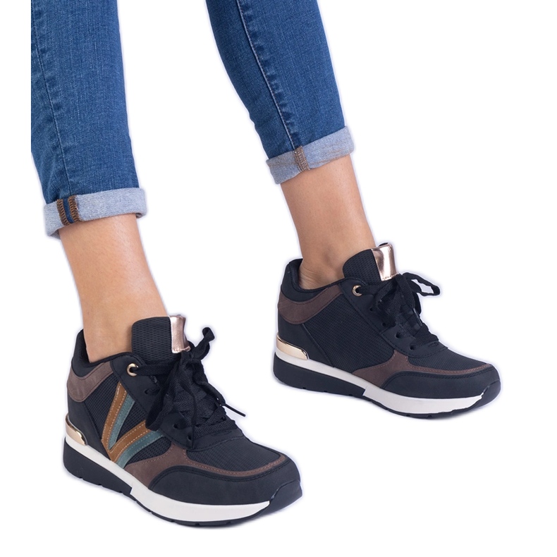 Sneaker da donna nera su un cuneo nascosto nero