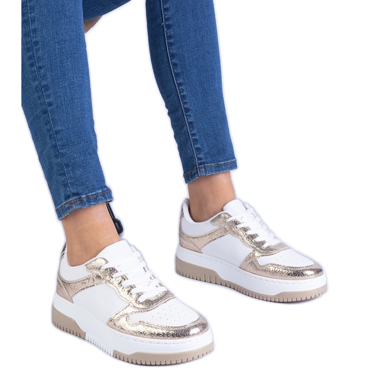 Sneaker dorate su una suola spessa d'oro