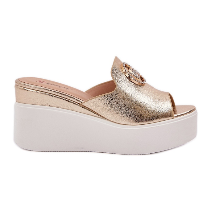 Pantofole sulla piattaforma e zeppe con un ornamento dorato d'oro