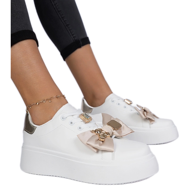 Sneaker bianche e oro femminili con un arco bianca