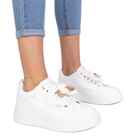 Sneaker bianche decorate con un arco e un orsacchiotto dorato bianca