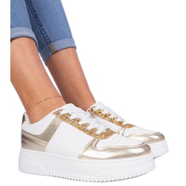 Sneaker da donna dorata su una suola spessa decorata con glitter d'oro