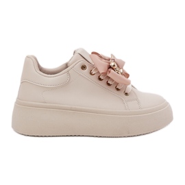 Sneaker femminili con un arco e una spilla con un orsacchiotto beige