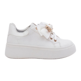 Sneaker femminili con un arco e una spilla con un orsacchiotto bianco