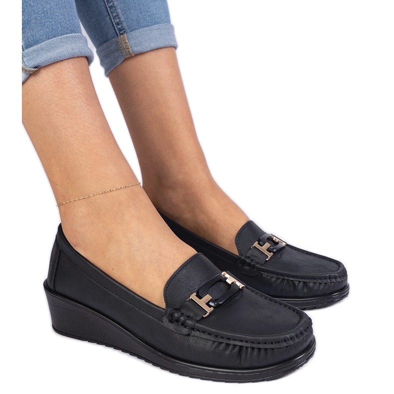 Mocassine delle donne nere sull'antico cuneo nero