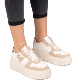 Le scarpe da ginnastica delle donne marroni con un cuore di broccato marrone