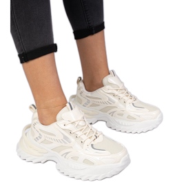 Sneaker sportive beige su una suola enorme
