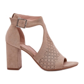 Sandali con un modello di lavoro aperto sul beige del pilastro Eco -Suede