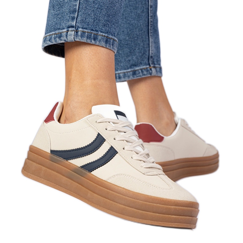 Sneaker beige sneaker da donna con un accessorio blu navy bianca