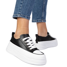 Sneaker da donna in bianco e nero su una suola alta bianca