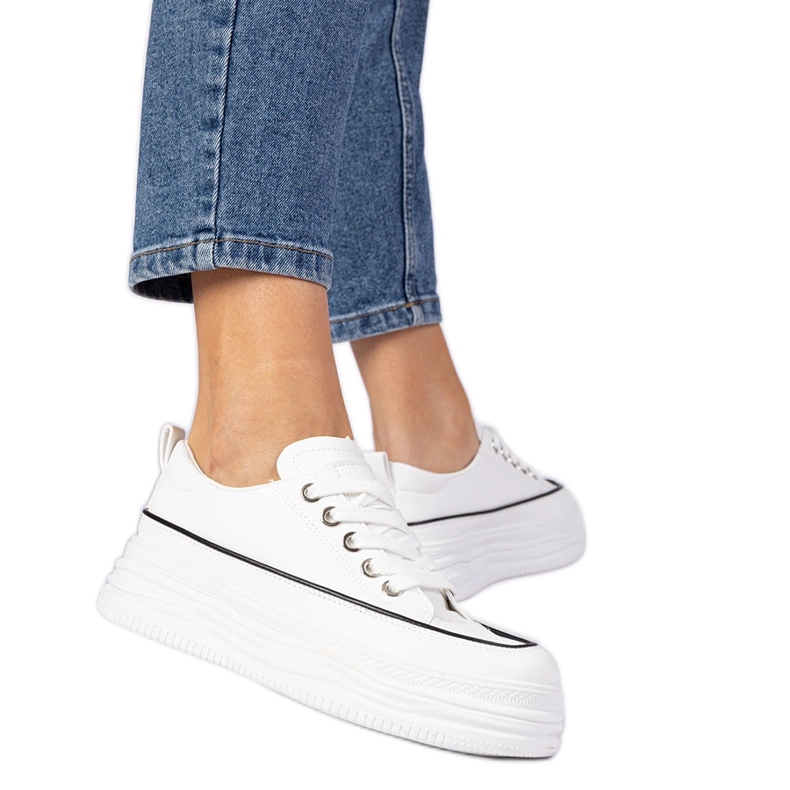 Sneaker da donna bianca su una suola alta