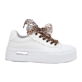 Sneaker femminili su una piattaforma enorme con allacciatura decorativa bianca