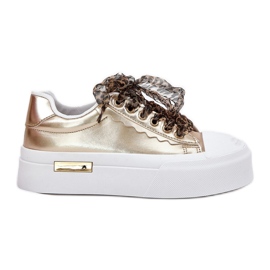 Sneaker femminili su una piattaforma enorme con oro allacciata decorativo d'oro