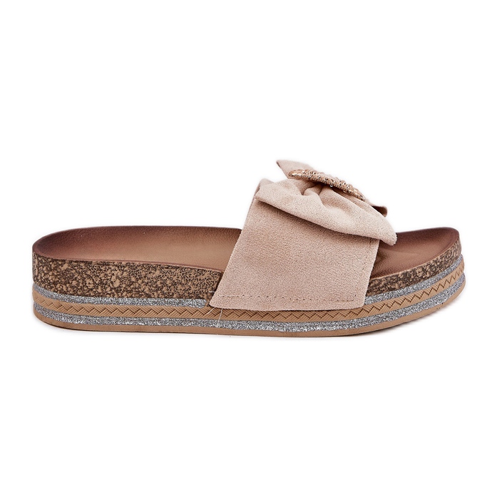 Infradito da donna sulla piattaforma con un arco e una spilla decorativa beige