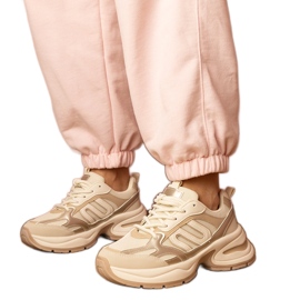 Sneaker sportive beige su una suola enorme