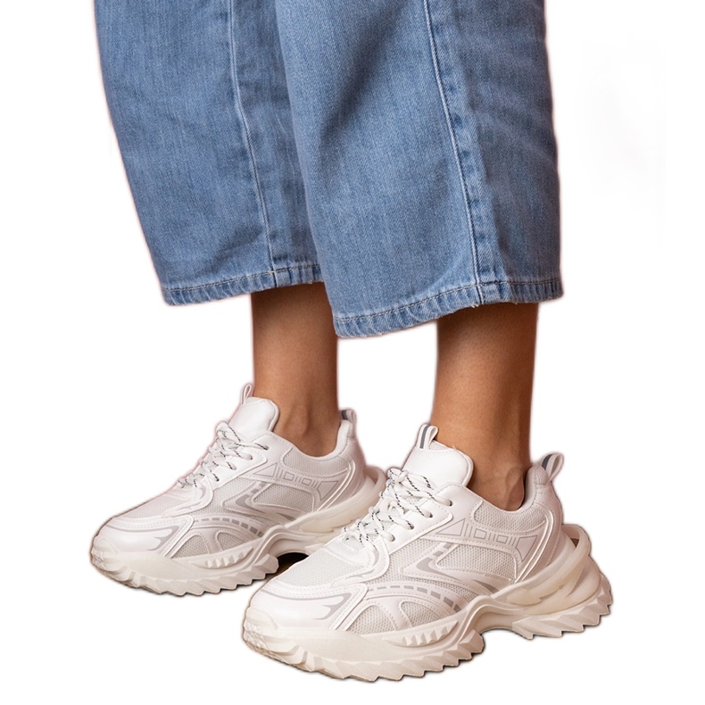 Sneaker sportivi bianchi su una suola spessa bianca