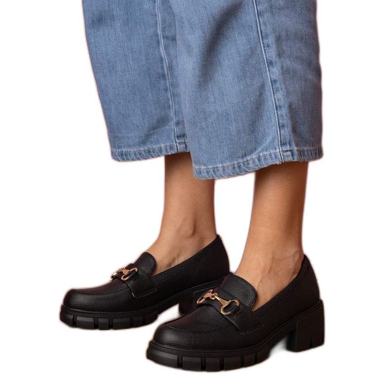 Scarpe nere su un post basso con una decorazione dorata nero