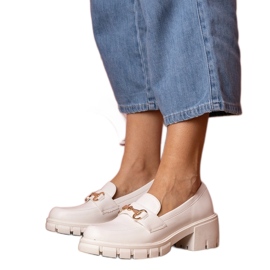 Scarpe bianche su un post basso con un ornamento dorato bianco