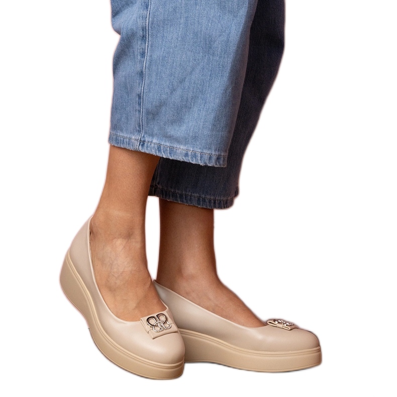 Scarpe beige sulla piattaforma con una decorazione di zircone