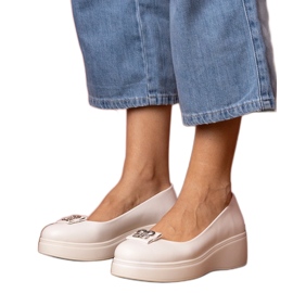 Scarpe bianche sulla piattaforma con una decorazione di zircone bianco