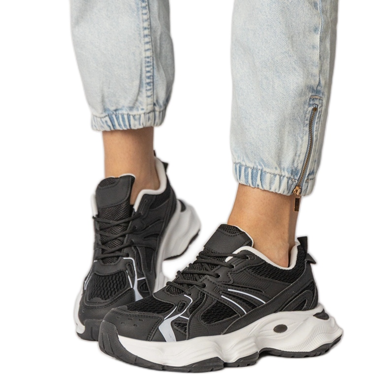 Sneaker sportive nere su una suola enorme nero