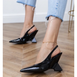 Sandali neri su un cuneo geometrico nero