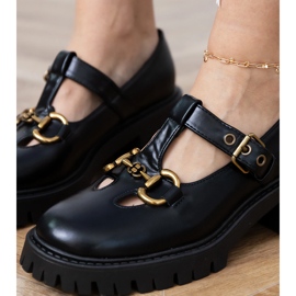 Scarpe nere su una suola spessa con una decorazione dorata nero