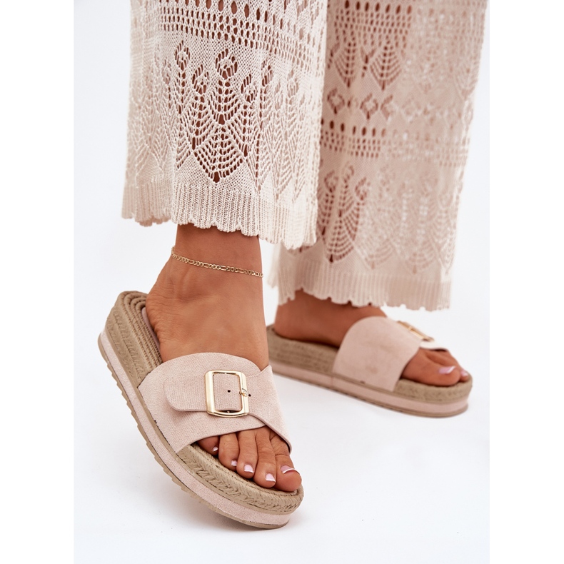 Le pantofole da donna sulla piattaforma con un beige di morsetto d'oro