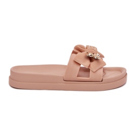 Le pantofole da donna con un arco e una spilla dorata beige