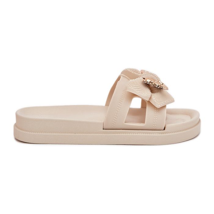Infradito da donna con un arco e una spilla luminosa dorata beige
