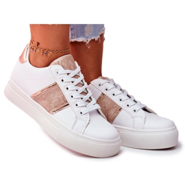 Le scarpe sportive da donna bianche e dorate continuano ad andare avanti bianco