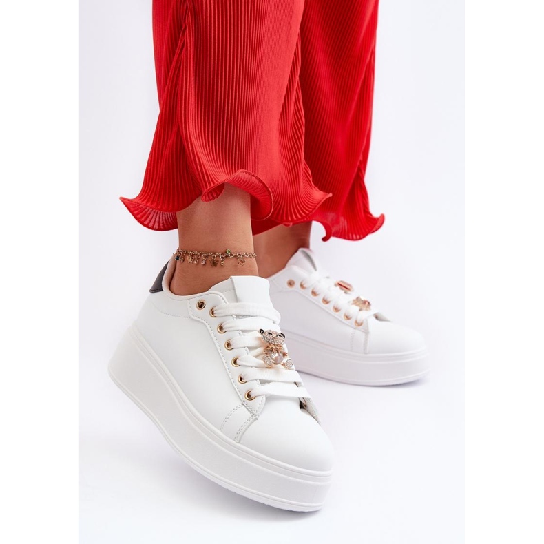 Scarpe sportive con una spilla bianca 1