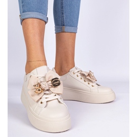 Sneaker beige decorate con un arco e un orsacchiotto dorato 2