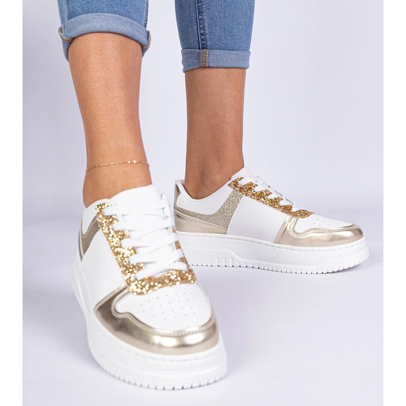 Sneaker da donna dorata su una suola spessa decorata con glitter d'oro 1