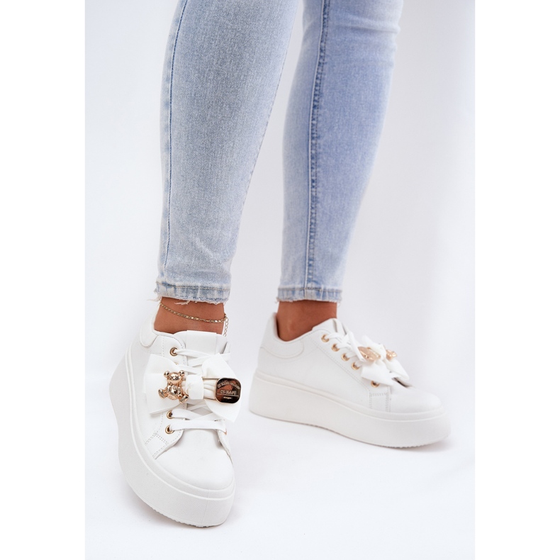 Sneaker femminili con un arco e una spilla con un orsacchiotto bianco 1