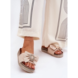 Infradito da donna sulla piattaforma con un arco e una spilla decorativa beige 2