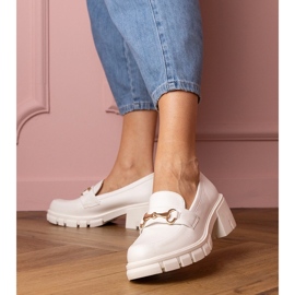 Scarpe bianche su un post basso con un ornamento dorato bianco 1