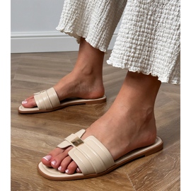 Le infradito da donna beige con un ornamento sulla cintura 1