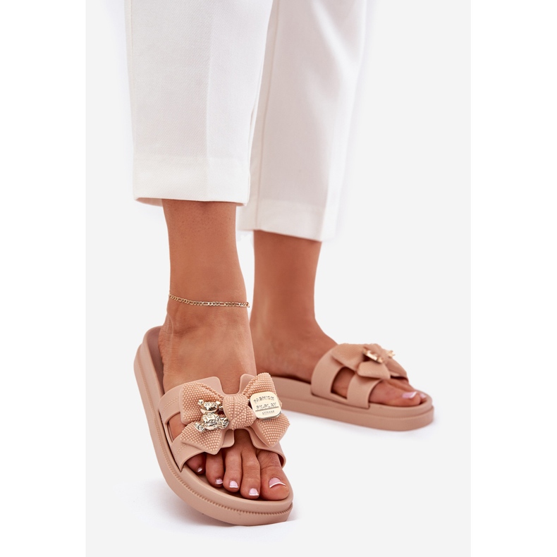 Le pantofole da donna con un arco e una spilla dorata beige 1