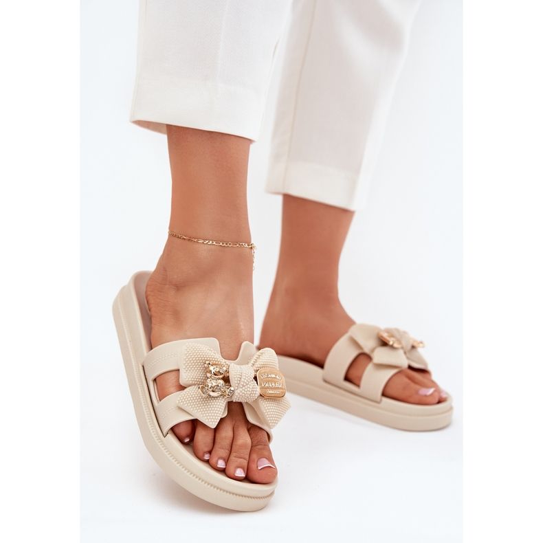 Infradito da donna con un arco e una spilla luminosa dorata beige 2